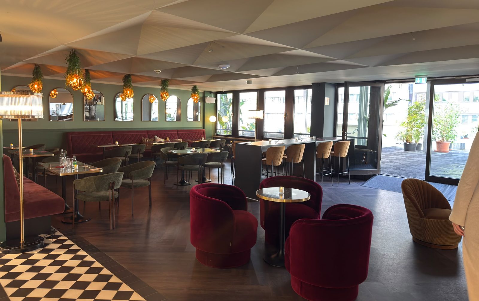 Das Bistro des De Blanc mit Bistrotischen, grünen Bänken und Bar